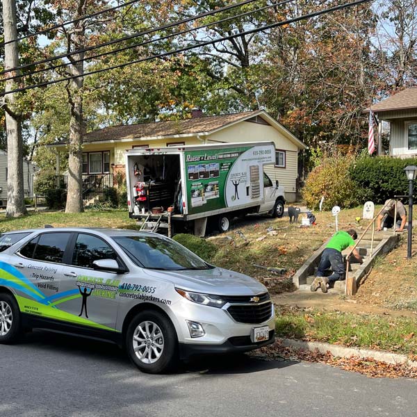 Concrete slab jacking crew lifting a residential sidewalk in Ashburn, VA Homes using specialized equipment and service vehicles.